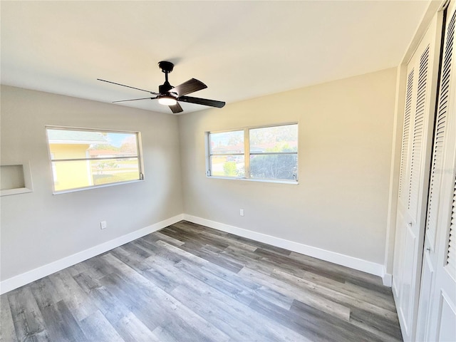 unfurnished bedroom featuring hardwood / wood-style floors, ceiling fan, and a closet