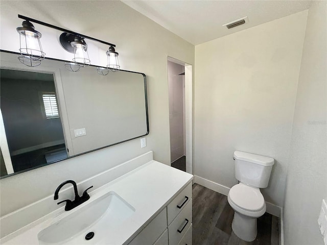 bathroom with vanity, wood-type flooring, walk in shower, and toilet