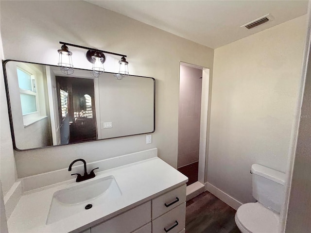 bathroom featuring vanity, a shower, hardwood / wood-style floors, and toilet