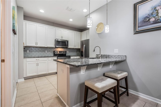 17523 Promenade Dr, Clermont, FL 34711 - kitchen with appliances with stainless steel finishes, a breakfast bar, sink, and white cabinets