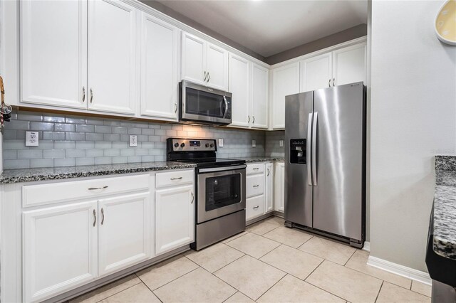 17523 Promenade Dr, Clermont, FL 34711 - kitchen featuring white cabinetry, stainless steel appliances, and dark stone countertops