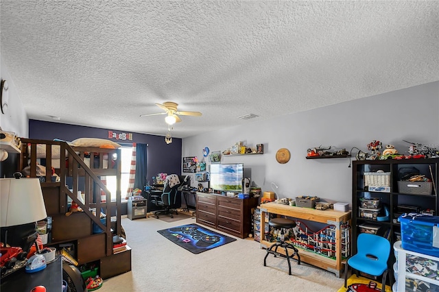 bedroom featuring a textured ceiling, visible vents, a ceiling fan, and light colored carpet