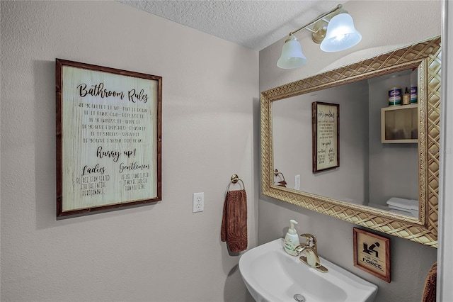 half bathroom featuring toilet, a textured ceiling, and a sink