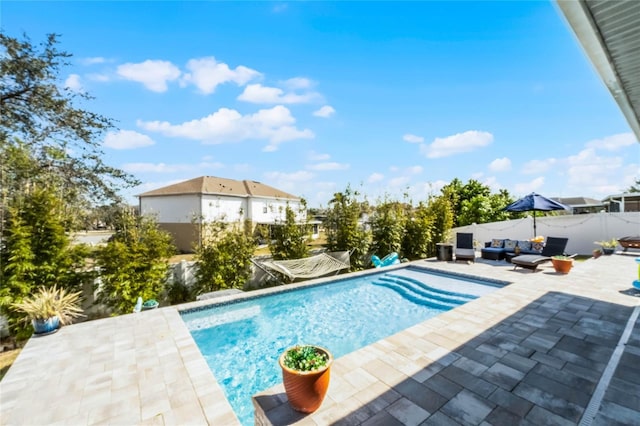 view of swimming pool featuring a patio area, outdoor lounge area, a fenced backyard, and a fenced in pool