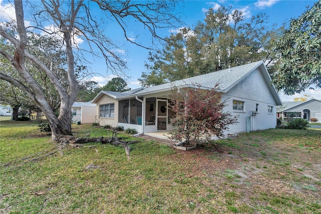 view of front of home with a front yard and a sunroom