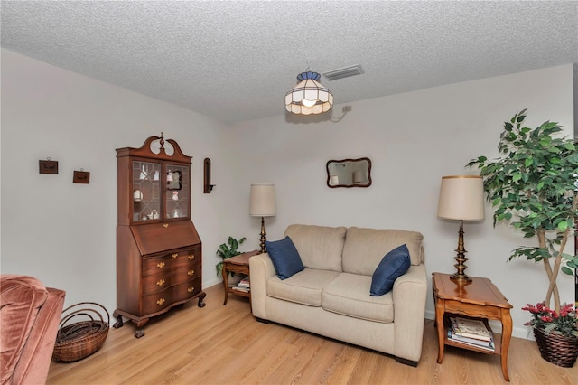 living room featuring a textured ceiling and light wood-type flooring