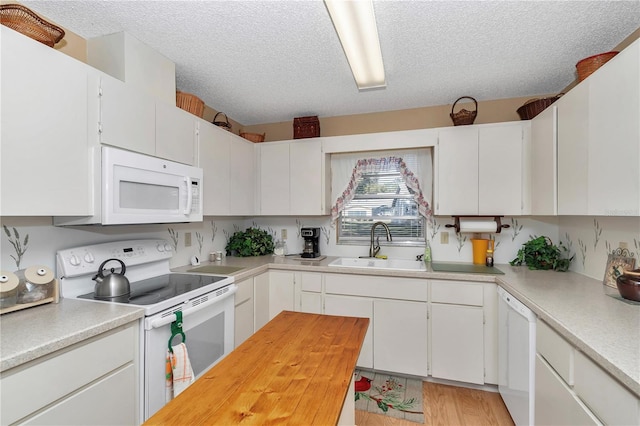 kitchen with sink, white appliances, and white cabinets