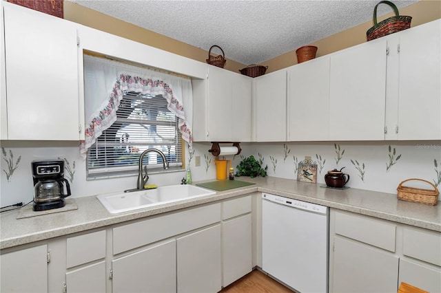 kitchen featuring sink, white dishwasher, a textured ceiling, white cabinets, and light wood-type flooring