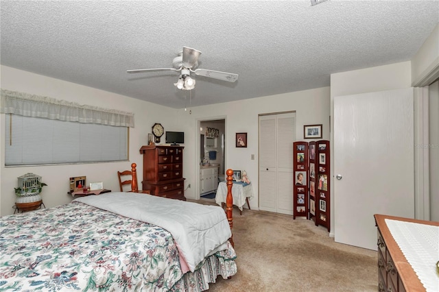 carpeted bedroom with ceiling fan, ensuite bath, a closet, and a textured ceiling