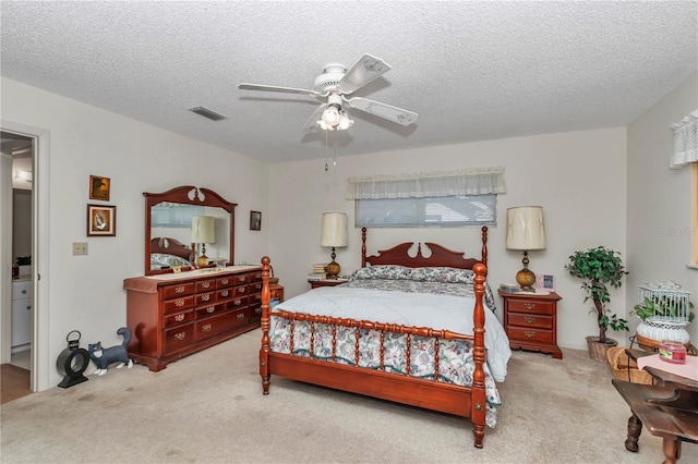 bedroom featuring light carpet, a textured ceiling, and ceiling fan