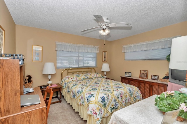 bedroom featuring ceiling fan, light carpet, and a textured ceiling