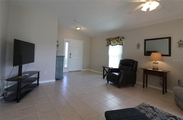 living room featuring lofted ceiling, light tile patterned floors, and ceiling fan