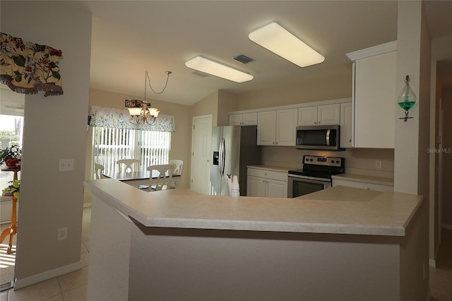 kitchen with white cabinetry, a chandelier, hanging light fixtures, light tile patterned floors, and stainless steel appliances