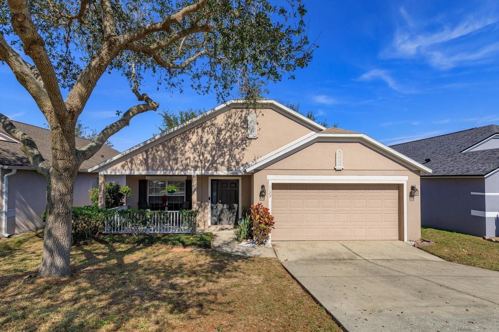 single story home featuring a garage, a front lawn, and covered porch