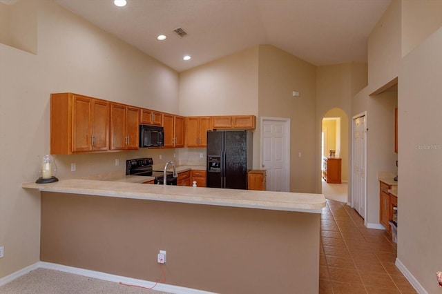 kitchen featuring light tile patterned floors, kitchen peninsula, high vaulted ceiling, and black appliances