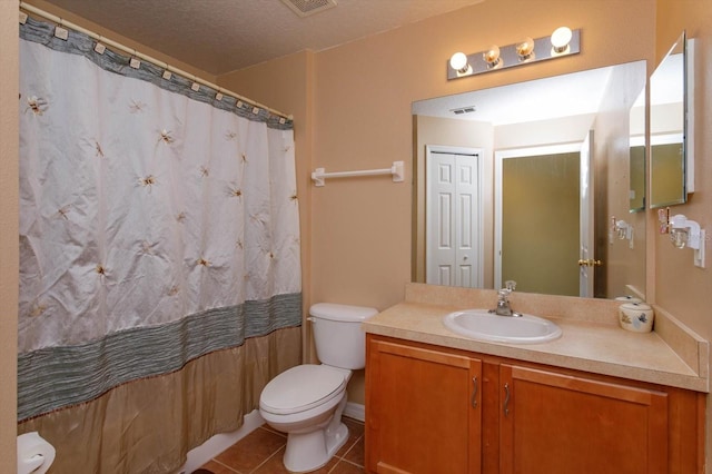 bathroom featuring tile patterned flooring, vanity, a textured ceiling, and toilet