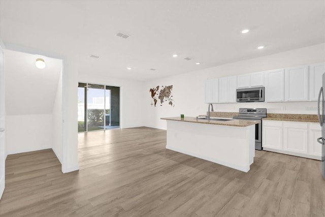 kitchen featuring sink, appliances with stainless steel finishes, a kitchen island with sink, white cabinets, and light wood-type flooring