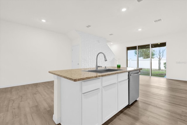 kitchen featuring a center island with sink, white cabinets, dishwasher, open floor plan, and a sink