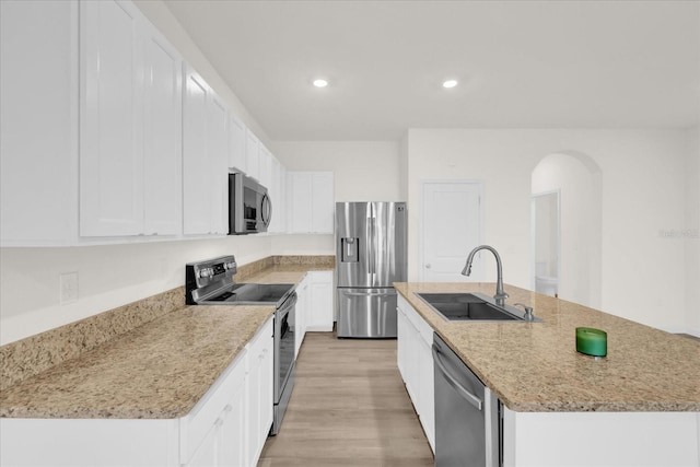 kitchen with a kitchen island with sink, appliances with stainless steel finishes, white cabinets, and a sink