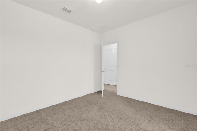 carpeted empty room with visible vents and baseboards