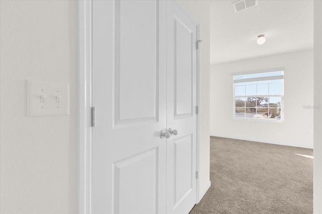 hallway with carpet floors and visible vents