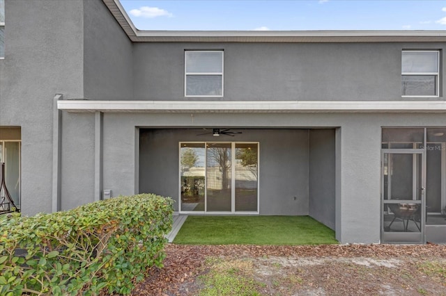 back of house featuring a ceiling fan and stucco siding