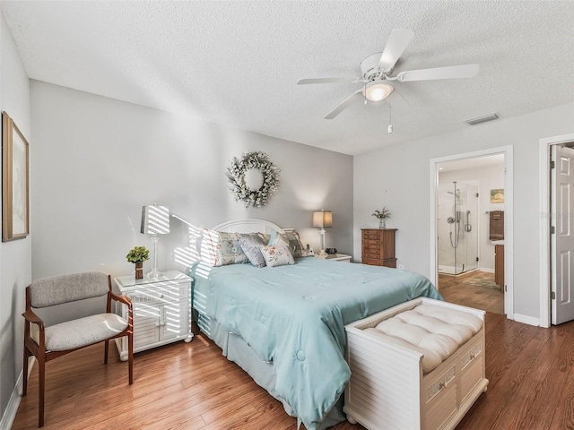 bedroom with hardwood / wood-style flooring, ceiling fan, ensuite bathroom, and a textured ceiling