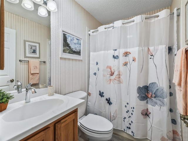 bathroom with a shower with curtain, vanity, a textured ceiling, and toilet