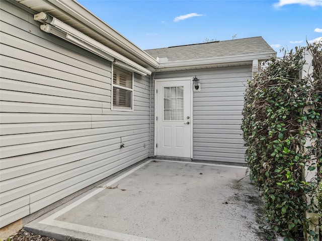 view of exterior entry with a patio