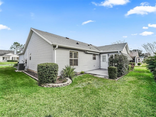 rear view of house with a yard, central AC, and a patio area