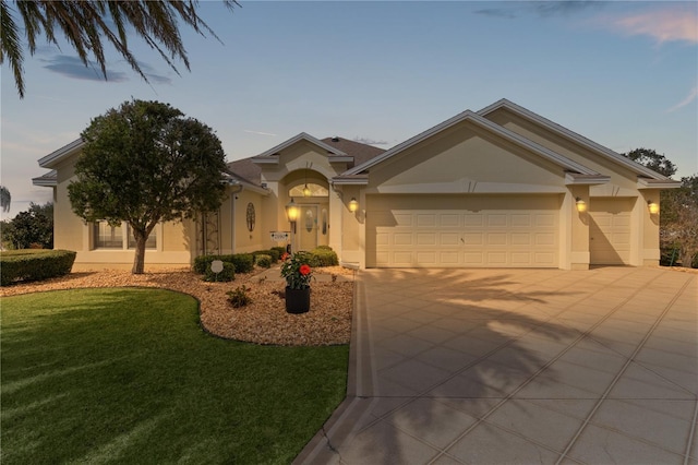 view of front of house with a garage and a lawn