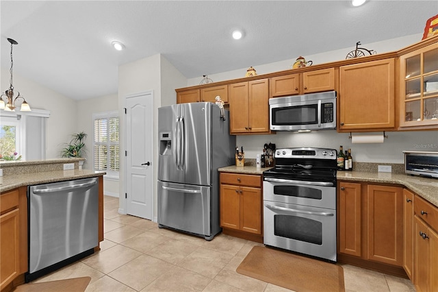 kitchen with light tile patterned flooring, lofted ceiling, pendant lighting, stainless steel appliances, and light stone countertops