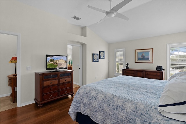 bedroom featuring ceiling fan, dark hardwood / wood-style flooring, vaulted ceiling, and multiple windows