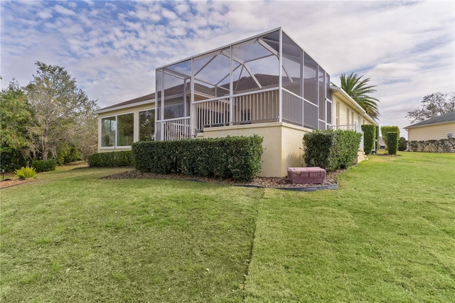 exterior space featuring a yard and glass enclosure