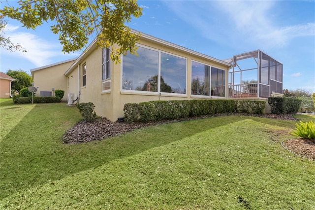 back of house featuring a lanai and a yard