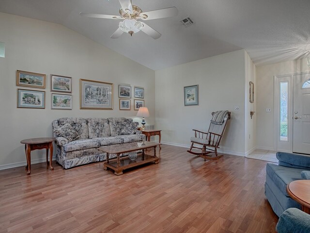 living room featuring ceiling fan, lofted ceiling, and light hardwood / wood-style floors