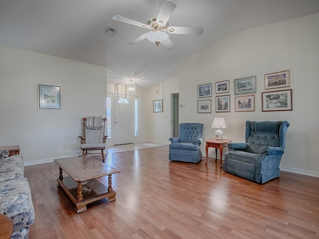 living room featuring vaulted ceiling, light hardwood / wood-style floors, and ceiling fan