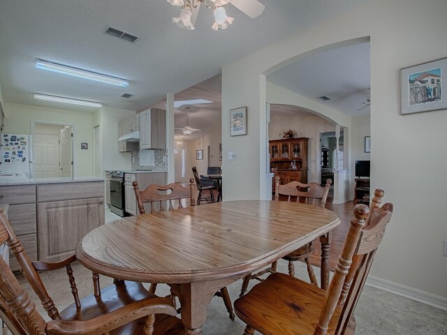 dining area with a textured ceiling and ceiling fan