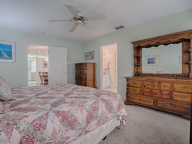 carpeted bedroom with ceiling fan and ensuite bath