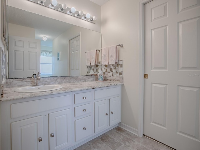 bathroom featuring vanity and backsplash