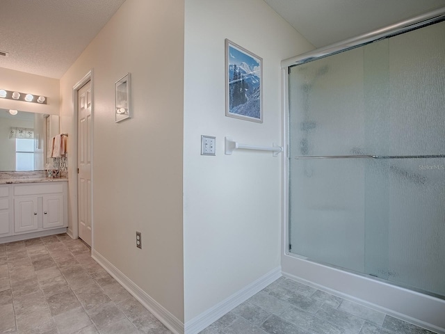 bathroom with vanity, enclosed tub / shower combo, and a textured ceiling