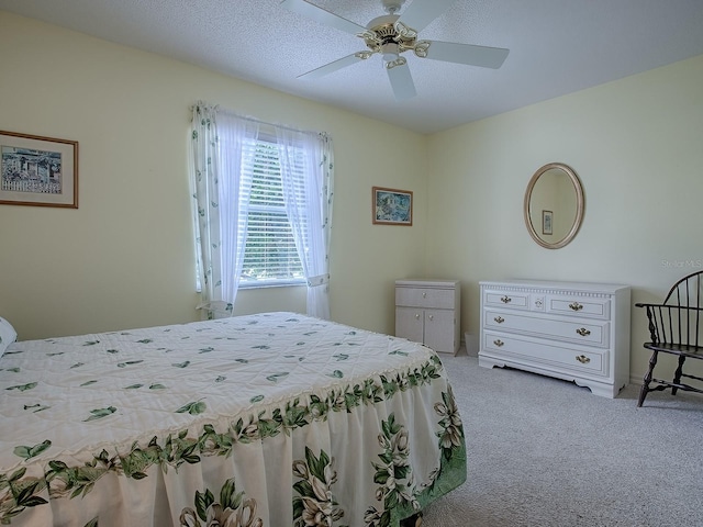 carpeted bedroom with a textured ceiling and ceiling fan