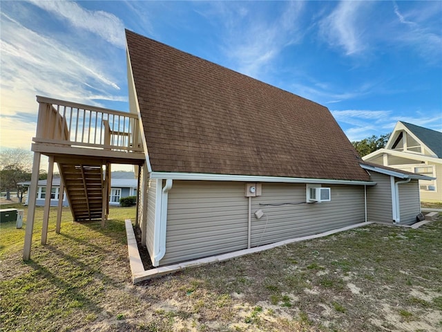 view of side of home with an AC wall unit, a deck, and a lawn