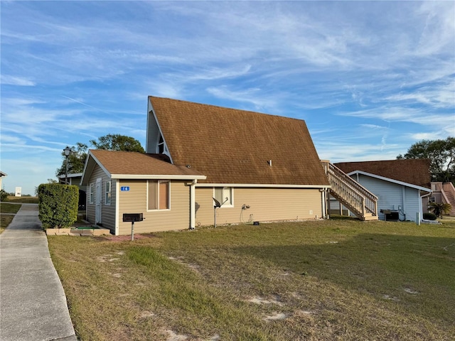 10301 US Highway 27 Unit 16, Clermont, FL 34711 - view of side of property featuring a yard, roof with shingles, and stairway