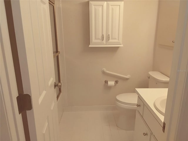 bathroom with baseboards, vanity, toilet, and tile patterned floors