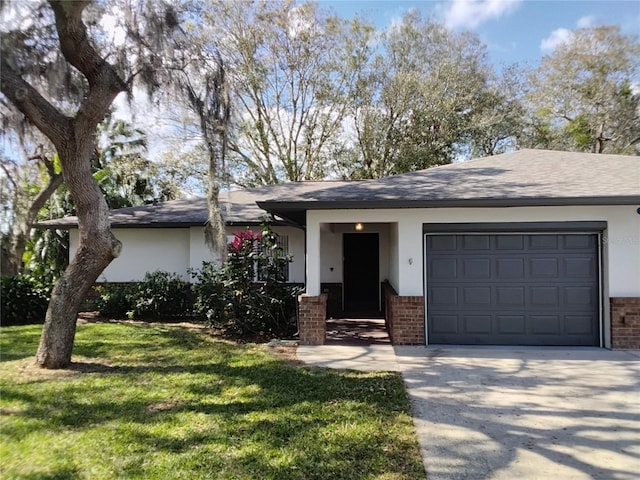 ranch-style home with an attached garage, brick siding, concrete driveway, stucco siding, and a front yard