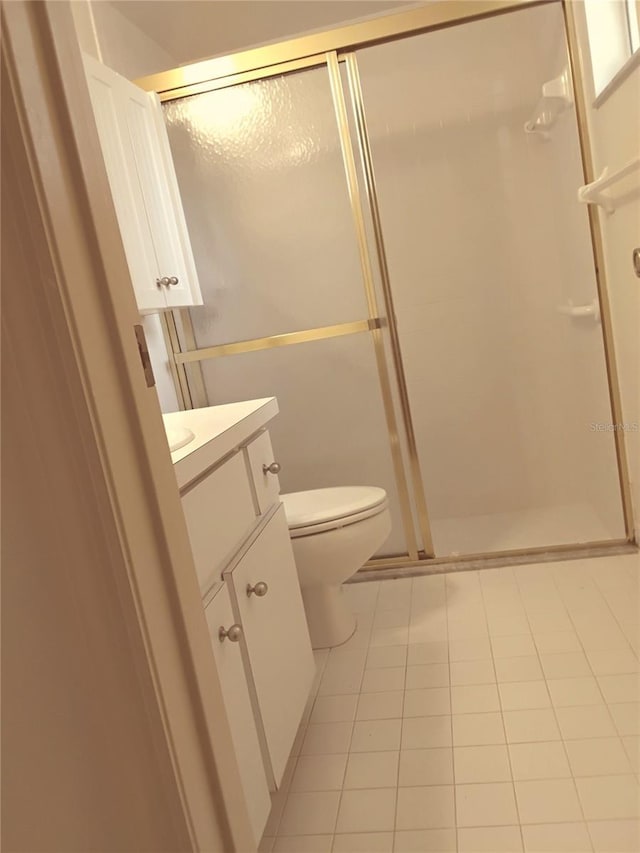 full bathroom featuring toilet, tile patterned floors, a shower stall, and vanity