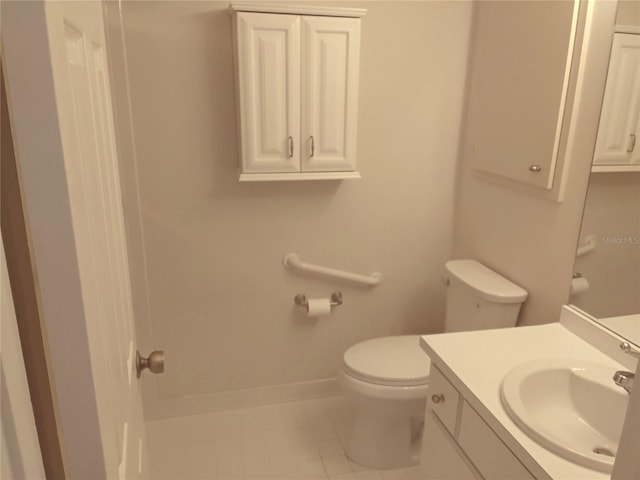 bathroom featuring tile patterned flooring, vanity, toilet, and baseboards