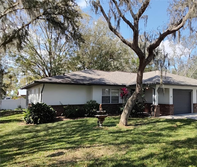 single story home featuring a garage, brick siding, a front yard, and stucco siding