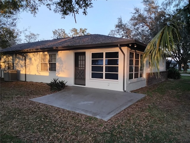 rear view of property featuring central AC, a patio, and stucco siding